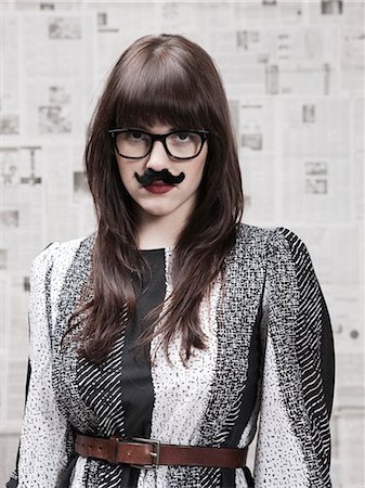 Studio portrait of young woman wearing fake moustache Foto de stock - Sin royalties Premium, Código: 640-03256383