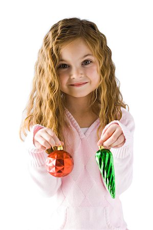 Studio portrait of girl (6-7) holding Christmas ornaments Stock Photo - Premium Royalty-Free, Code: 640-03256422