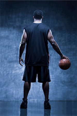 Male basketball player holding ball, studio shot Stock Photo - Premium Royalty-Free, Code: 640-03256467