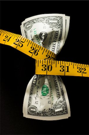 debt scales - One dollar banknotes tied up with measuring tape against black background Stock Photo - Premium Royalty-Free, Code: 640-03256488