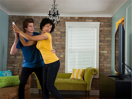 USA, Utah, Provo, young couple holding remote control in living room Foto de stock - Sin royalties Premium, Código: 640-03256584