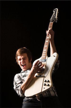 Young man playing electric guitar, studio shot Foto de stock - Royalty Free Premium, Número: 640-03256631