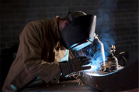 simsearch:640-03256646,k - USA, Utah, Orem, man welding metal in workshop Stock Photo - Premium Royalty-Free, Code: 640-03256645