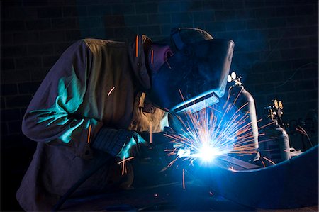 protective work wear - USA, Utah, Orem, man welding metal in workshop Stock Photo - Premium Royalty-Free, Code: 640-03256646