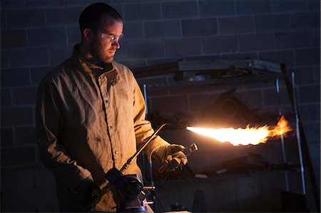 protective work wear - USA, Utah, Orem, male welder using blowtorch in workshop Stock Photo - Premium Royalty-Free, Code: 640-03256651