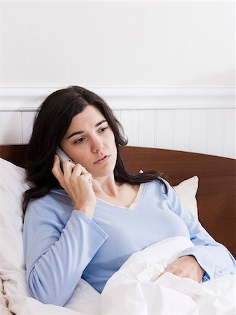 Orem, Utah, USA, young ill woman in bed talking on cordless phone Stock Photo - Premium Royalty-Free, Code: 640-03256711