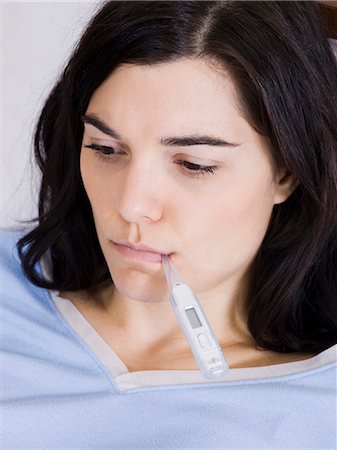 Orem, Utah, USA, young woman with thermometer in mouth Stock Photo - Premium Royalty-Free, Code: 640-03256722
