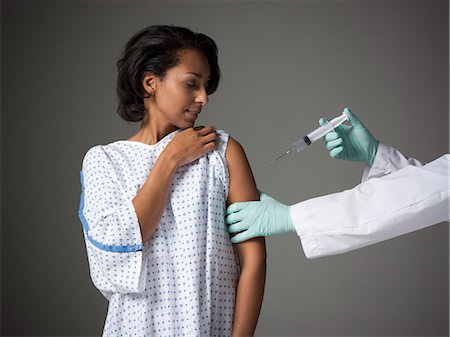 Mid adult woman receiving injection Stock Photo - Premium Royalty-Free, Code: 640-03256731