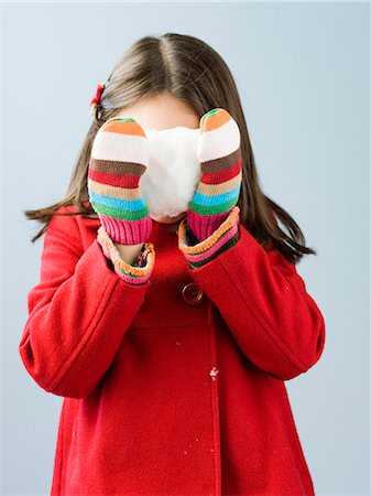 Girl (6-7) in red coat holding fresh snow ball Stock Photo - Premium Royalty-Free, Code: 640-03256752