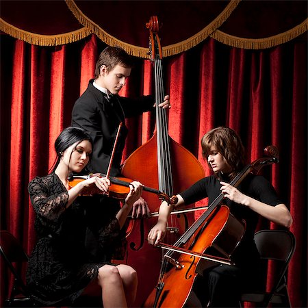 formal man sitting - Three young musicians playing in orchestra Stock Photo - Premium Royalty-Free, Code: 640-03256795