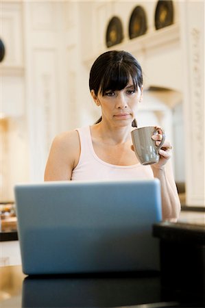 simsearch:640-03256844,k - USA, Utah, Alpine, mid adult woman sitting behind laptop and holding mug Stock Photo - Premium Royalty-Free, Code: 640-03256838
