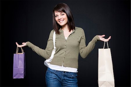 simsearch:640-03257317,k - Studio portrait of young woman holding shopping bags Fotografie stock - Premium Royalty-Free, Codice: 640-03256998