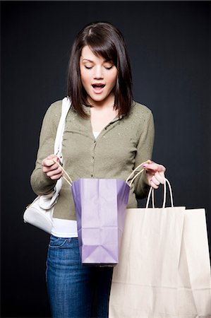 simsearch:640-03257317,k - Studio portrait of young woman holding shopping bags Fotografie stock - Premium Royalty-Free, Codice: 640-03256999