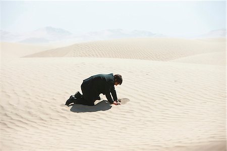 USA, Utah, Little Sahara, mid adult businessman digging hole on desert Foto de stock - Sin royalties Premium, Código: 640-03257069