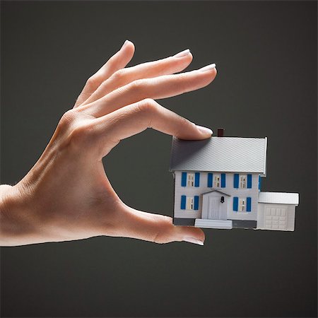 simsearch:640-03257126,k - Young woman's hand holding toy house Fotografie stock - Premium Royalty-Free, Codice: 640-03257111