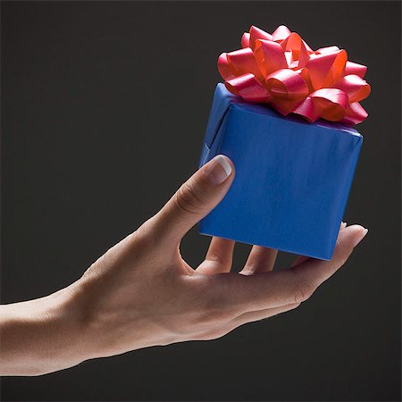 simsearch:640-03257126,k - Young woman's hand holding wrapped gift Fotografie stock - Premium Royalty-Free, Codice: 640-03257113
