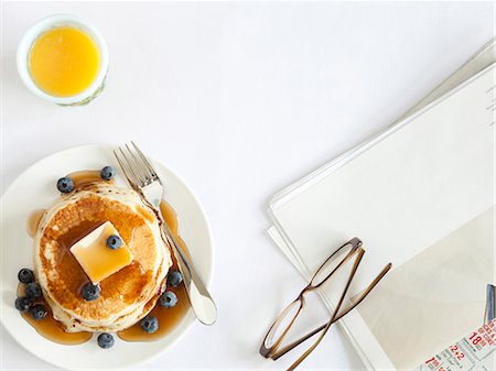 pancake breakfast - USA, California, San Francisco, blueberry pancakes with eyeglasses and juice on table, overhead view Stock Photo - Premium Royalty-Free, Code: 640-03257276