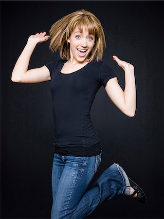 people young jumping happy - Young cheerful woman jumping, studio shot Stock Photo - Premium Royalty-Free, Code: 640-03257319