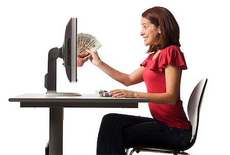 Conceptual picture of young woman receiving paper money out of her computer Stock Photo - Premium Royalty-Free, Code: 640-03257414