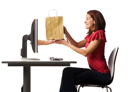 e commerce - Conceptual picture of young woman receiving shopping bag out of her computer Stock Photo - Premium Royalty-Free, Code: 640-03257412