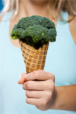 Young woman holding broccoli ice cream Stock Photo - Premium Royalty-Free, Code: 640-03257520