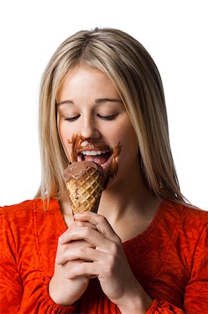 eating indulgent chocolate - Studio portrait of young woman eating ice cream Stock Photo - Premium Royalty-Free, Code: 640-03257521