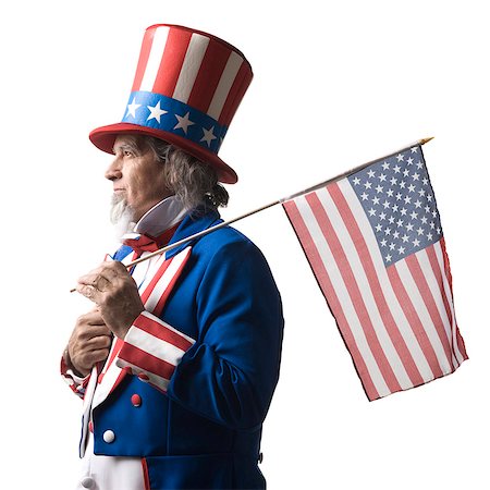 Homme en costume de l'oncle Sam, tenant le drapeau américain, studio shot Photographie de stock - Premium Libres de Droits, Code: 640-03257617