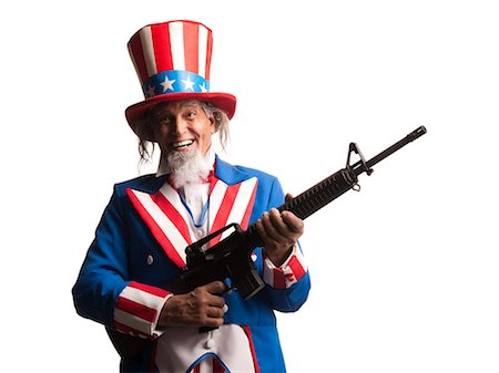 Man in Uncle Sam's costume with gun, studio shot Stock Photo - Premium Royalty-Free, Code: 640-03257624