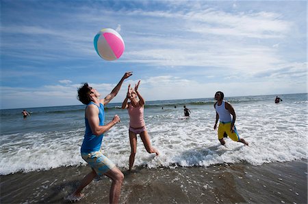 simsearch:640-03258792,k - Trois adultes jouant avec un ballon de plage Photographie de stock - Premium Libres de Droits, Code: 640-03258771