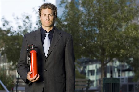 estintore - Businessman with fire extinguisher Fotografie stock - Premium Royalty-Free, Codice: 640-03258861