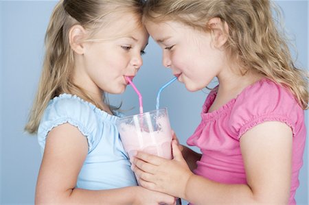 Deux jeunes filles partage un milkshake Photographie de stock - Premium Libres de Droits, Code: 640-03259649