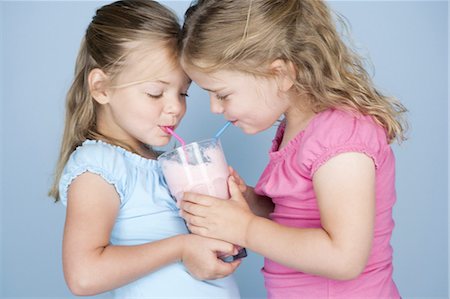 Two girls sharing a milkshake Stock Photo - Premium Royalty-Free, Code: 640-03259650