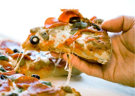 eating pizza - Hand slicing pizza Foto de stock - Sin royalties Premium, Código: 640-03259668