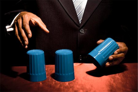 disappear - Man doing a trick with three cups Foto de stock - Sin royalties Premium, Código: 640-03259951