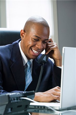 Homme d'affaires sur ordinateur portable et sur le téléphone Photographie de stock - Premium Libres de Droits, Code: 640-03259975