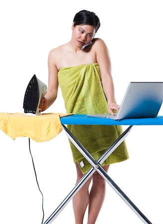 Woman ironing and working on laptop Stock Photo - Premium Royalty-Free, Code: 640-03264695