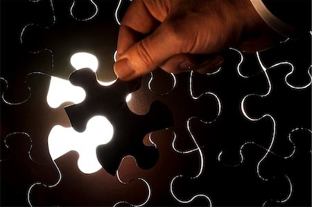 puzzle piece - Hand inserting piece of jigsaw puzzle Foto de stock - Sin royalties Premium, Código: 640-03264769