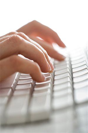 Close-up of fingers typing on keyboard Fotografie stock - Premium Royalty-Free, Codice: 640-03264794