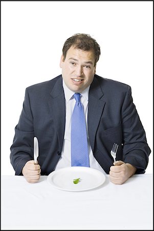 disinteressato - Overweight businessman eating a small salad Fotografie stock - Premium Royalty-Free, Codice: 640-03265138