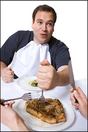 fat man food - Overweight man stealing steak off partner's plate Stock Photo - Premium Royalty-Free, Code: 640-03265147