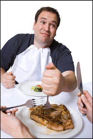 fat man food - Overweight man stealing steak off partner's plate Stock Photo - Premium Royalty-Free, Code: 640-03265148