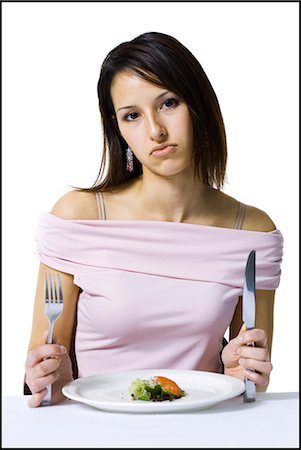 Woman on a diet eating a small salad Stock Photo - Premium Royalty-Free, Code: 640-03265142