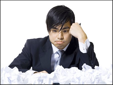 Frustrated businessman surrounded by crumpled papers Stock Photo - Premium Royalty-Free, Code: 640-03265193