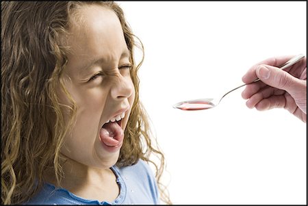 sciroppo - Young girl taking a spoonful of medicine Fotografie stock - Premium Royalty-Free, Codice: 640-03265242