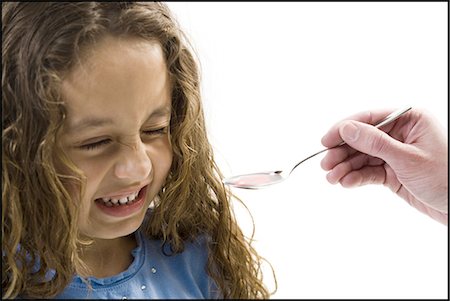 Young girl taking a spoonful of medicine Foto de stock - Sin royalties Premium, Código: 640-03265243