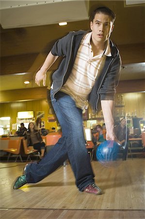Young man bowling in a bowling alley Stock Photo - Premium Royalty-Free, Code: 640-03265555