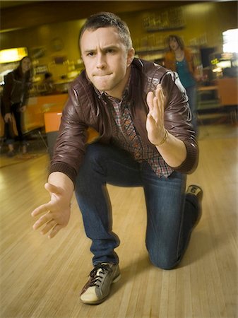 relaxing wood floor guy - Young man cheering in excitement at a bowling alley Stock Photo - Premium Royalty-Free, Code: 640-03265571