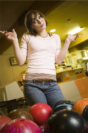 simsearch:640-03265586,k - Low angle view of a teenage girl looking at bowling balls and scratching her head Stock Photo - Premium Royalty-Free, Code: 640-03265616