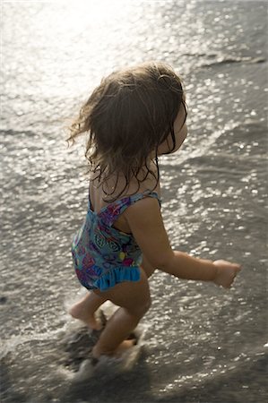 High angle view of a toddler girl running on the beach Stock Photo - Premium Royalty-Free, Code: 640-03265648