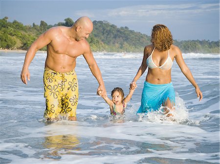 father and daughter surf beach - Un homme et une femme qui marche sur la plage avec leur fille Photographie de stock - Premium Libres de Droits, Code: 640-03265656